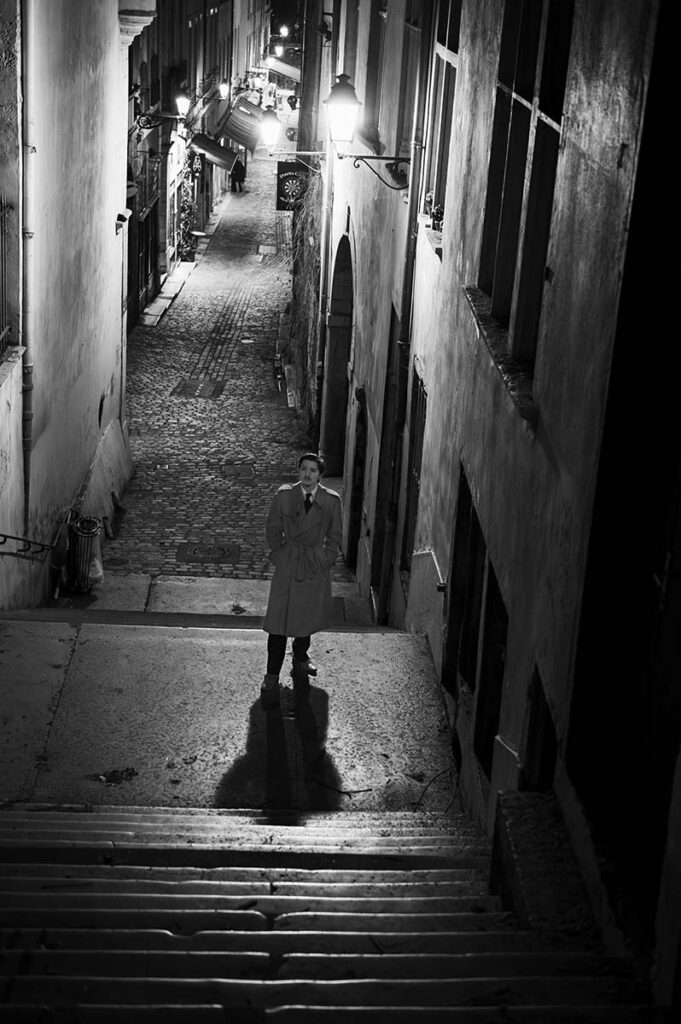 Homme seul au milieu de la rue le soir en noir et blanc